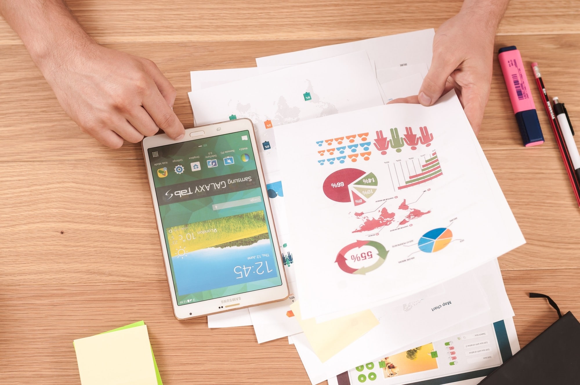 Cell phone on a desk with page of infographics beside it